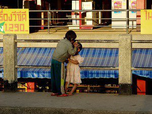 a boy removing lice from her little sister